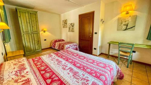 a hotel room with two beds and a desk at Residence Villa Frejus in Bardonecchia