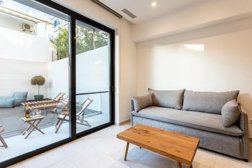 a living room with a couch and a table at Grec Suites Dafni, Athens by GrecCollection in Athens