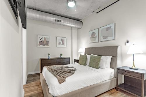 a bedroom with a bed and two tables with lamps at Experience St. Pete Charming 1 Bed by Tropicana in St Petersburg