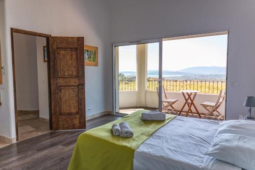 une chambre avec un lit et un balcon avec vue dans l'établissement Villa Dolce, à Sainte-Lucie de Porto-Vecchio