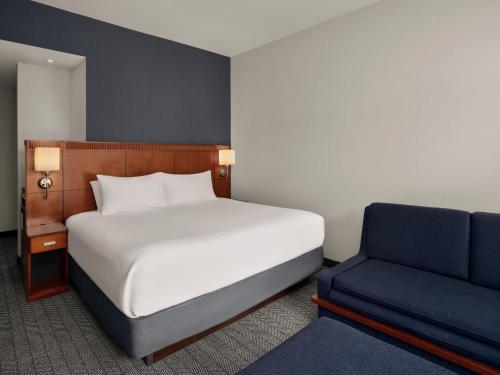 a bedroom with a bed and a blue chair at Courtyard by Marriott Halifax Downtown in Halifax