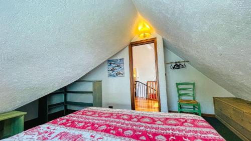 a attic room with a bed and a staircase at Residence Villa Frejus in Bardonecchia