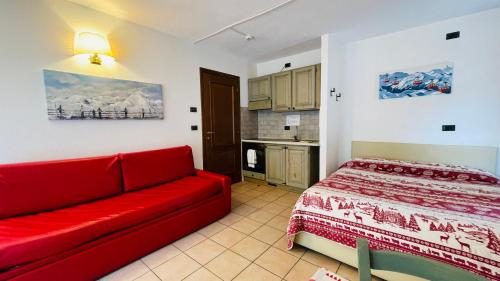 a living room with a red couch and a kitchen at Residence Villa Frejus in Bardonecchia