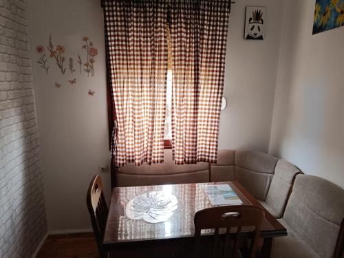 a table and a couch in a room with a window at WIN apartment in Pluzine