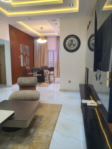 Una sala de estar con televisión y un comedor. en Grazioli 2Bedroom Apartment 'Florence', en Enugu Airport