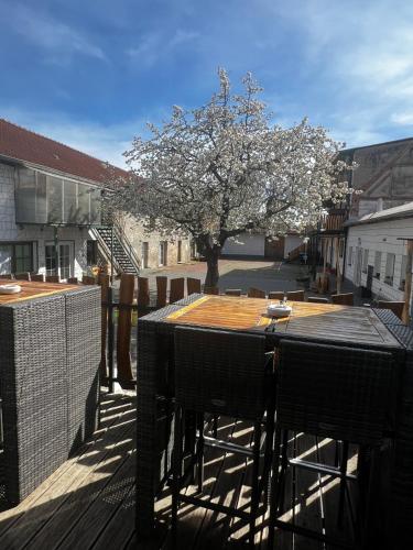 a table and chairs on a deck with a tree at Unseburger Brauhaus GmbH Ferienwohnung 5 in Unseburg
