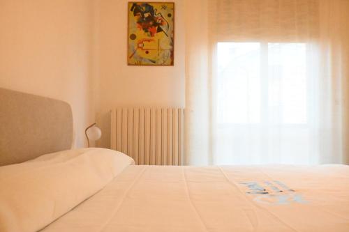 a bedroom with a white bed and a window at SE148 - Marotta, trilocale con terrazzo e posto auto in Marotta