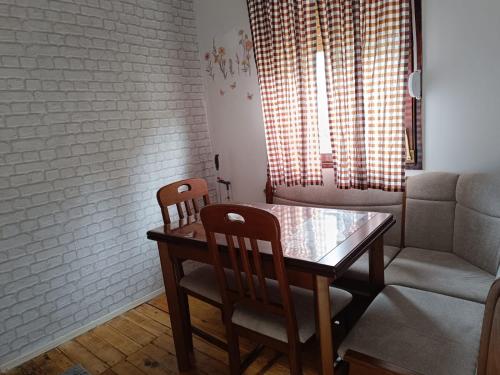 a dining room with a table and chairs and a couch at WIN apartment in Pluzine