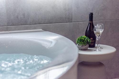 a bath tub with a bottle of wine and wine glasses at - NumberZ - Rooms Apartments and Suites with Wi-Fi and AC in Borgo Isonzo