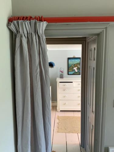 a room with a door with a curtain and a dresser at Beautiful, airy flat with Park views in Leamington Spa