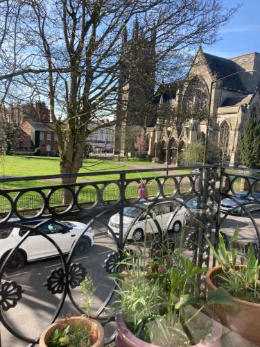 two white cars parked in front of a church at Beautiful, airy flat with Park views in Leamington Spa
