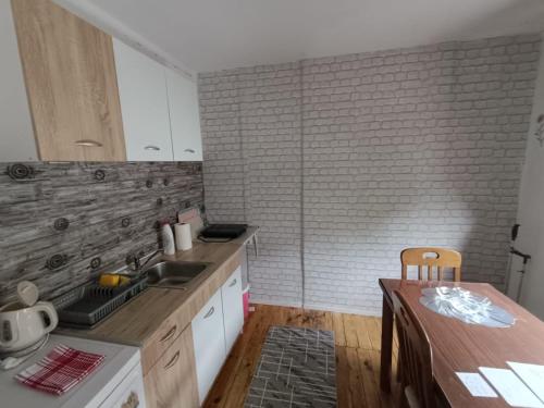 a kitchen with a counter and a wooden table at WIN apartment in Pluzine