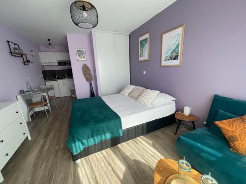 une petite chambre avec un lit et un canapé dans l'établissement Studio cosy, résidence de tourisme avec piscine, à Aix-en-Provence