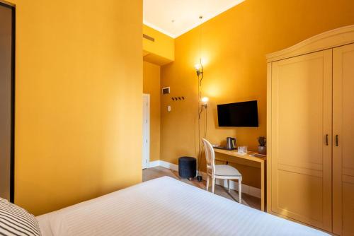 a hotel room with a bed and a desk with a computer at San Giovanni Terme Rapolano in Rapolano Terme