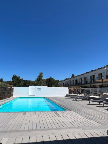 une piscine avec deux bancs et un bâtiment dans l'établissement Studio cosy, résidence de tourisme avec piscine, à Aix-en-Provence