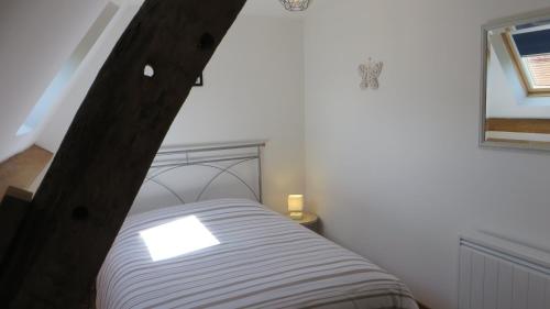 a bedroom with a bed with a wooden headboard at La Ferme de Frévan in Sarceaux