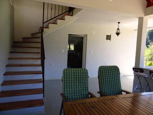 a dining room with a table and chairs and a staircase at Kuca Aura in Višegrad