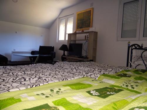 a bedroom with a bed and a table and a desk at Kuca Aura in Višegrad