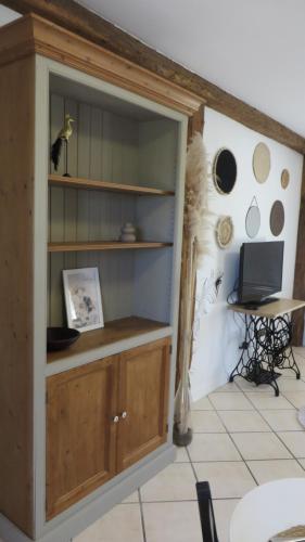 a room with a book shelf with a laptop on it at La Ferme de Frévan in Sarceaux