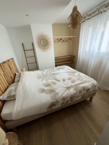 une chambre avec un lit avec une couette blanche dans l'établissement La Bali house, à Voiron