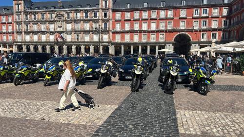 a woman walking past a row of parked motorcycles at la bella de plaza mayor in Madrid