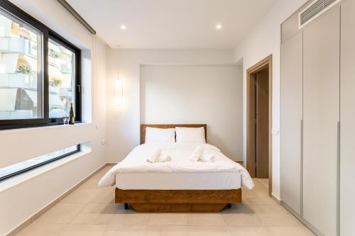 a bedroom with a bed and a window at Grec Suites Dafni, Athens by GrecCollection in Athens