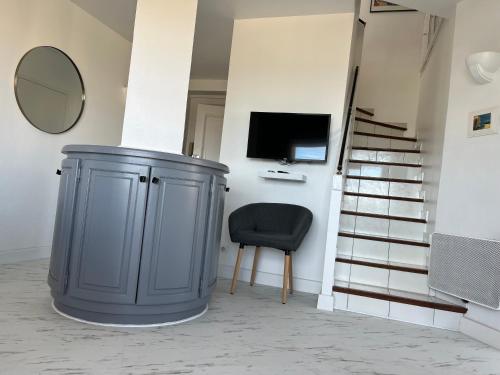 une chambre avec une poubelle, une chaise et une télévision dans l'établissement Palais du soleil, à La Celle-sous-Gouzon