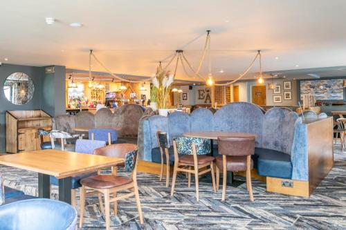 a restaurant with blue booths and tables and chairs at Shelly's Stay in Port Carlisle