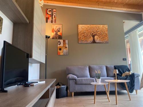 a living room with a couch and a tree on the wall at MONTE MISONE 2.0 in Comano Terme
