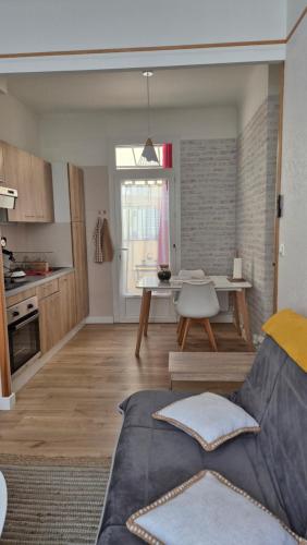 un salon et une cuisine avec un canapé et une table dans l'établissement L'Appartement Gabriel, à Bergerac