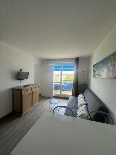 un salon avec un canapé et une télévision dans l'établissement T2 Bord de plage, résidence Bleu Marine 85, à Lacanau-Océan