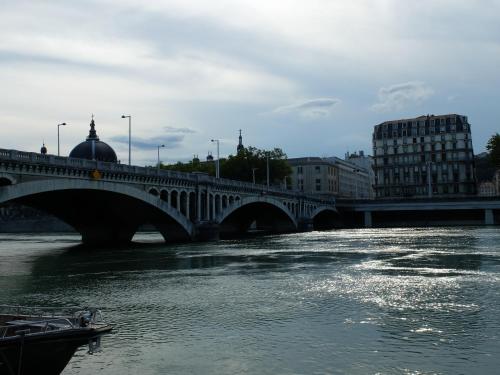 a bridge over a river with a boat in the water at Jolie chambre à louer - Vue Imprenable in Lyon