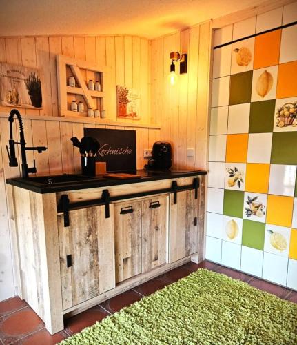 a kitchen with a counter and a green rug at FeWo Italien in Neue Scheune