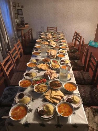 a long table with plates of food on it at Zuriko Kakhiani's Guest House in Zhabeshi