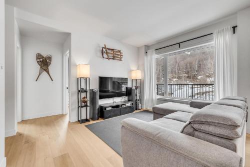 un soggiorno con un divano e una TV di Initial - the chalet - MSA SKI IN and OUT a Beaupré