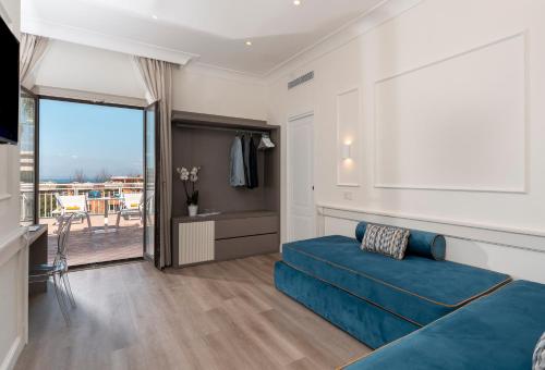 ソレントにあるHotel Michelangeloのベッドルーム(青いベッド1台、バルコニー付)
