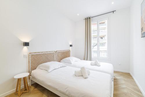 une chambre blanche avec deux lits et une fenêtre dans l'établissement Large & Confort 2 Bdr Renovated, à Nice