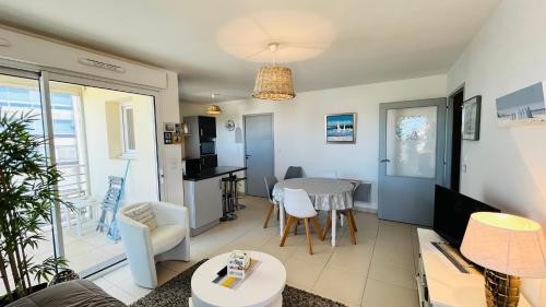 un salon avec une cuisine et une table dans l'établissement Immersion marine, T2 front de mer, à Saint-Hilaire-de-Riez