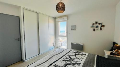 une chambre avec un lit et une grande fenêtre dans l'établissement Immersion marine, T2 front de mer, à Saint-Hilaire-de-Riez