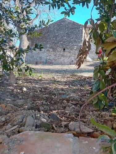 un bâtiment en pierre au loin avec un arbre dans l'établissement La Forge 1846, à Servas
