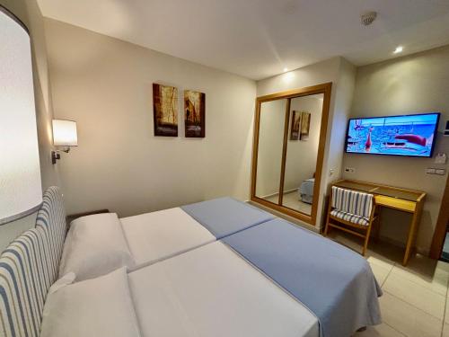 a hotel room with a bed and a television at Hotel La Cala Finestrat in Cala de Finestrat