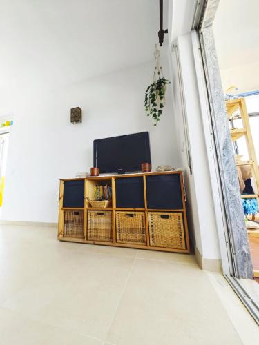 a living room with a television on a wooden cabinet at Blife Paulya private apartment in FAO