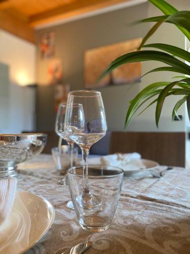 a table with wine glasses and plates on it at MONTE MISONE 2.0 in Comano Terme