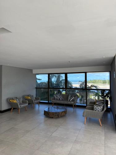 a living room with couches and a table at Beach Flats Barra Home Stay By Flatbpaiva in Recife