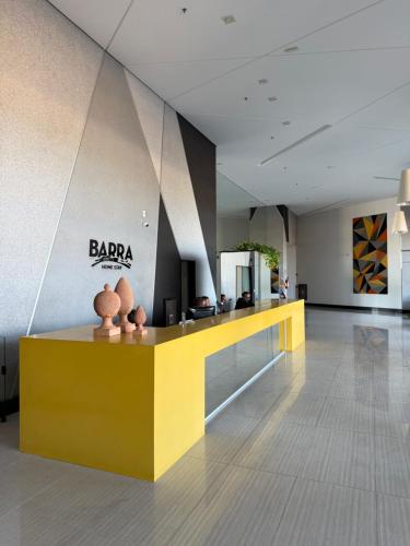 a lobby with a yellow counter in a building at Beach Flats Barra Home Stay By Flatbpaiva in Recife