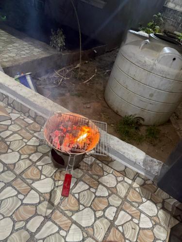 a fire pit sitting on the ground next to a barrel at My Dream in Manduar