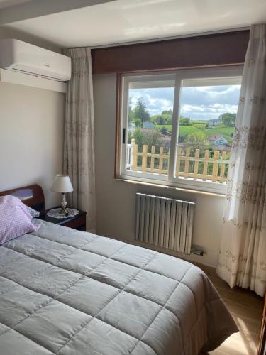 a bedroom with a bed and a large window at Piso acogedor con vistas in Val do Dubra