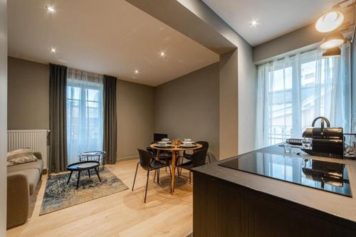 une cuisine et un salon avec une table et des chaises dans l'établissement Appart standing Belval plein centre 4 parking, à Aix-les-Bains