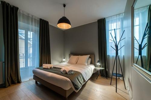 une chambre avec un lit avec deux serviettes dessus dans l'établissement Appart standing Belval plein centre 4 parking, à Aix-les-Bains