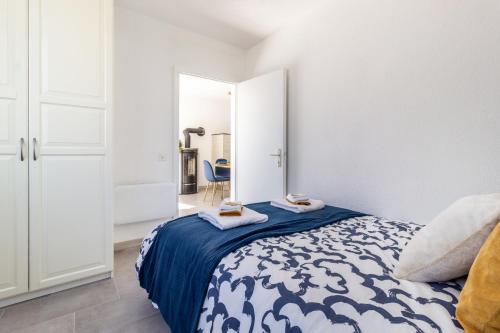 1 dormitorio con 1 cama con manta azul y espejo en Lake View and Relaxation, Locarno, en Locarno